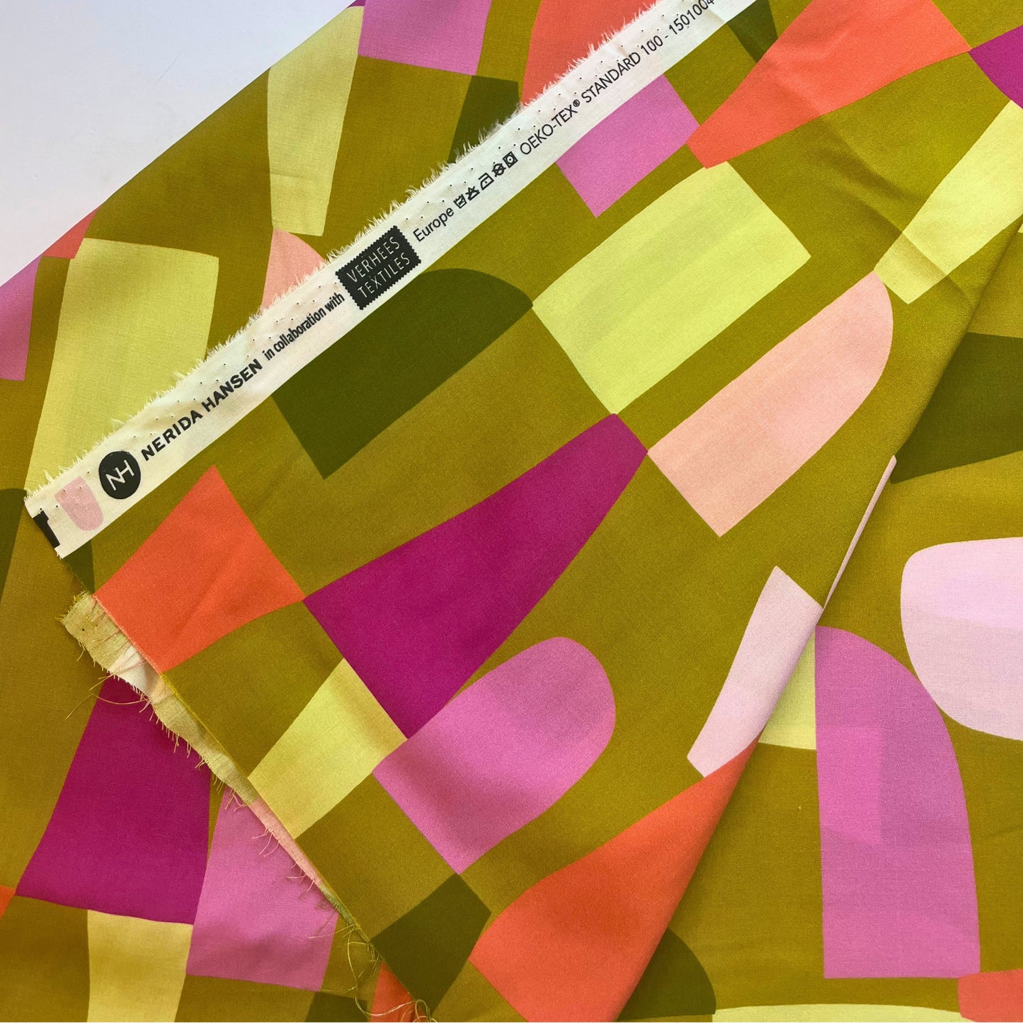 Draped LENZING™ ECOVERO™ Shape Shifter fabric in contemporary green and white print, ideal for sewing dresses, jumpsuits, and blouses.