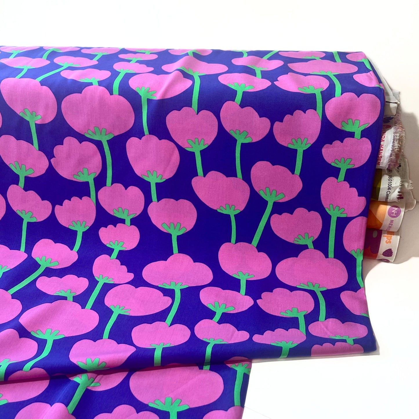 Detail view of colourful cotton bud pattern on purple base, made from 100% eco-responsible LENZING™ ECOVERO™ viscose.