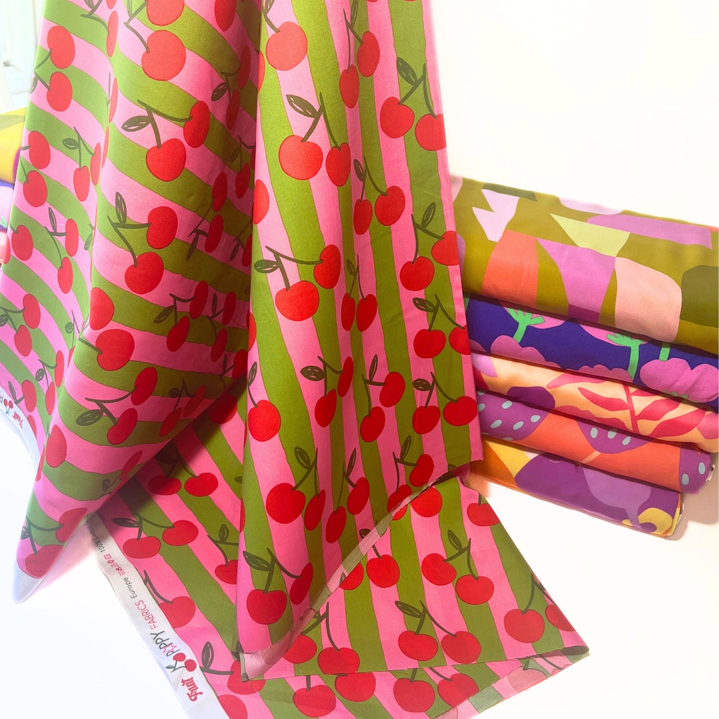 Detail of Cherry Stripe Cotton Poplin, soft and crisp fabric perfect for feel-good DIY dressmaking with a fruity twist.