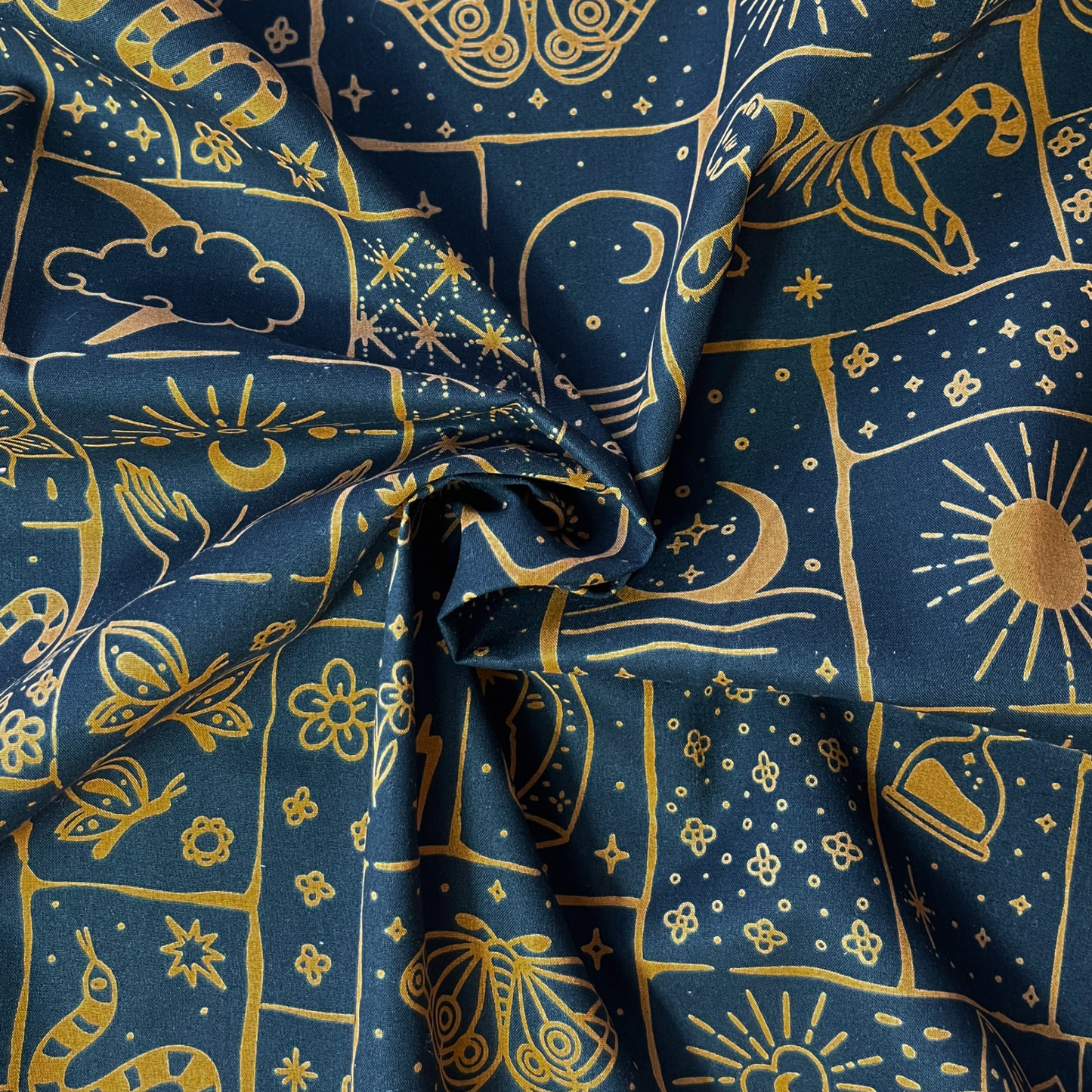 Black cotton poplin with irregular caramel and ginger celestial patchwork print featuring tigers, florals, stars and moons — Oeko-Tex Standard 100 certified 100% cotton woven for bold slow fashion dressmaking and statement handmade garments