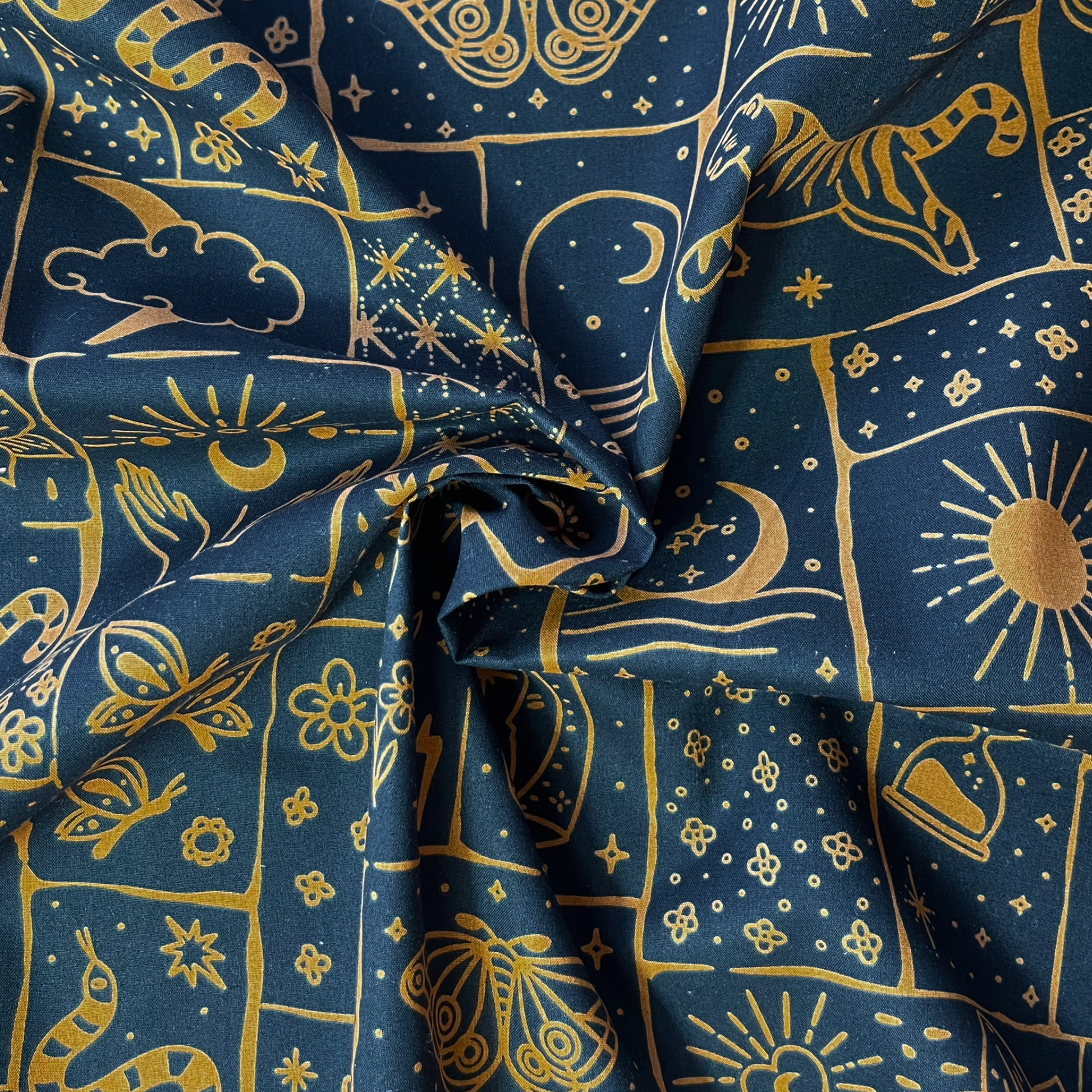 Black cotton poplin with irregular caramel and ginger celestial patchwork print featuring tigers, florals, stars and moons — Oeko-Tex Standard 100 certified 100% cotton woven for bold slow fashion dressmaking and statement handmade garments