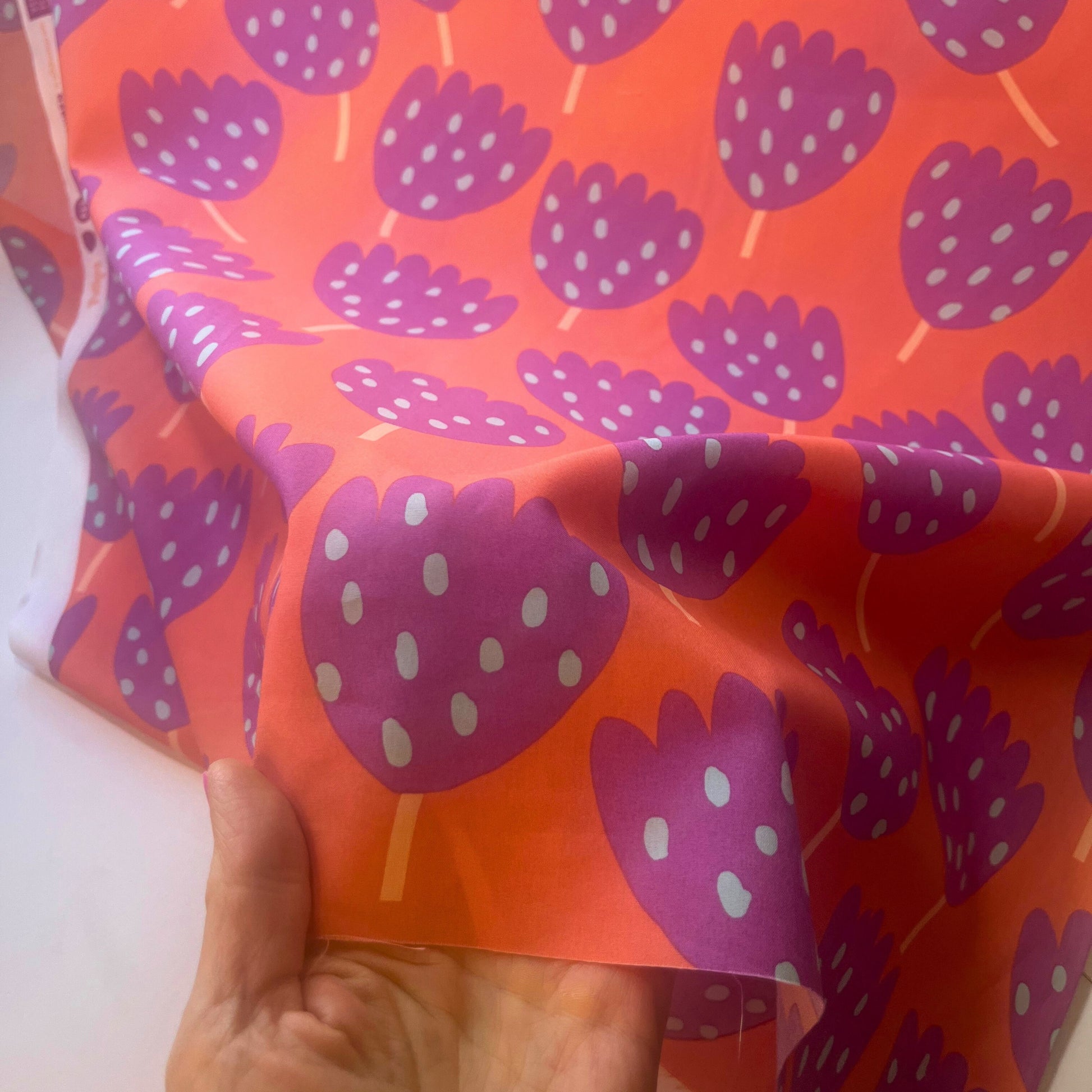 Close-up of stylised tulip flower design in bright coral and purple on 100% Oeko-Tex certified cotton.