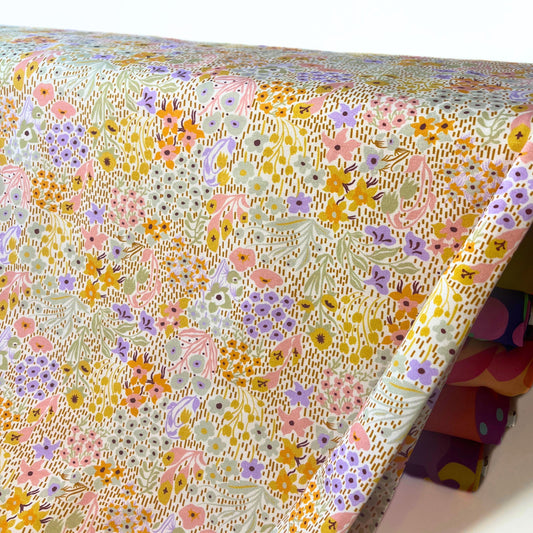 Softly coloured wildflower jersey cotton fabric with gentle spring florals on a white background – perfect for handmade children’s clothes.