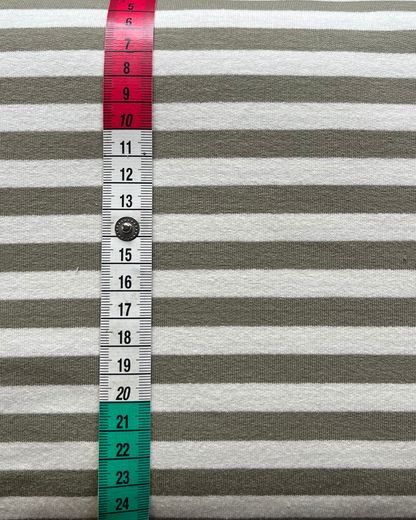 Close-up of moss green and warm white yarn dyed stripe French terry, showing clean stripe definition on smooth face and soft looped reverse visible at fold