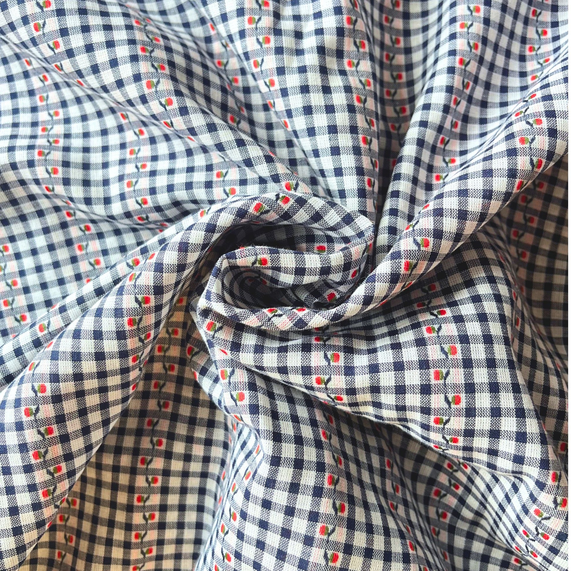 Close-up of navy and white mini gingham cotton fabric showing delicate raised jacquard floral pattern and red highlight detail — Oeko-Tex Standard 100 certified, ideal for slow fashion dressmaking