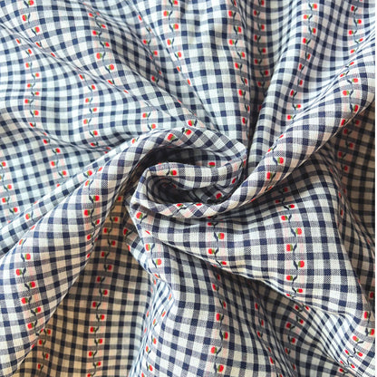 Close-up of navy and white mini gingham cotton fabric showing delicate raised jacquard floral pattern and red highlight detail — Oeko-Tex Standard 100 certified, ideal for slow fashion dressmaking