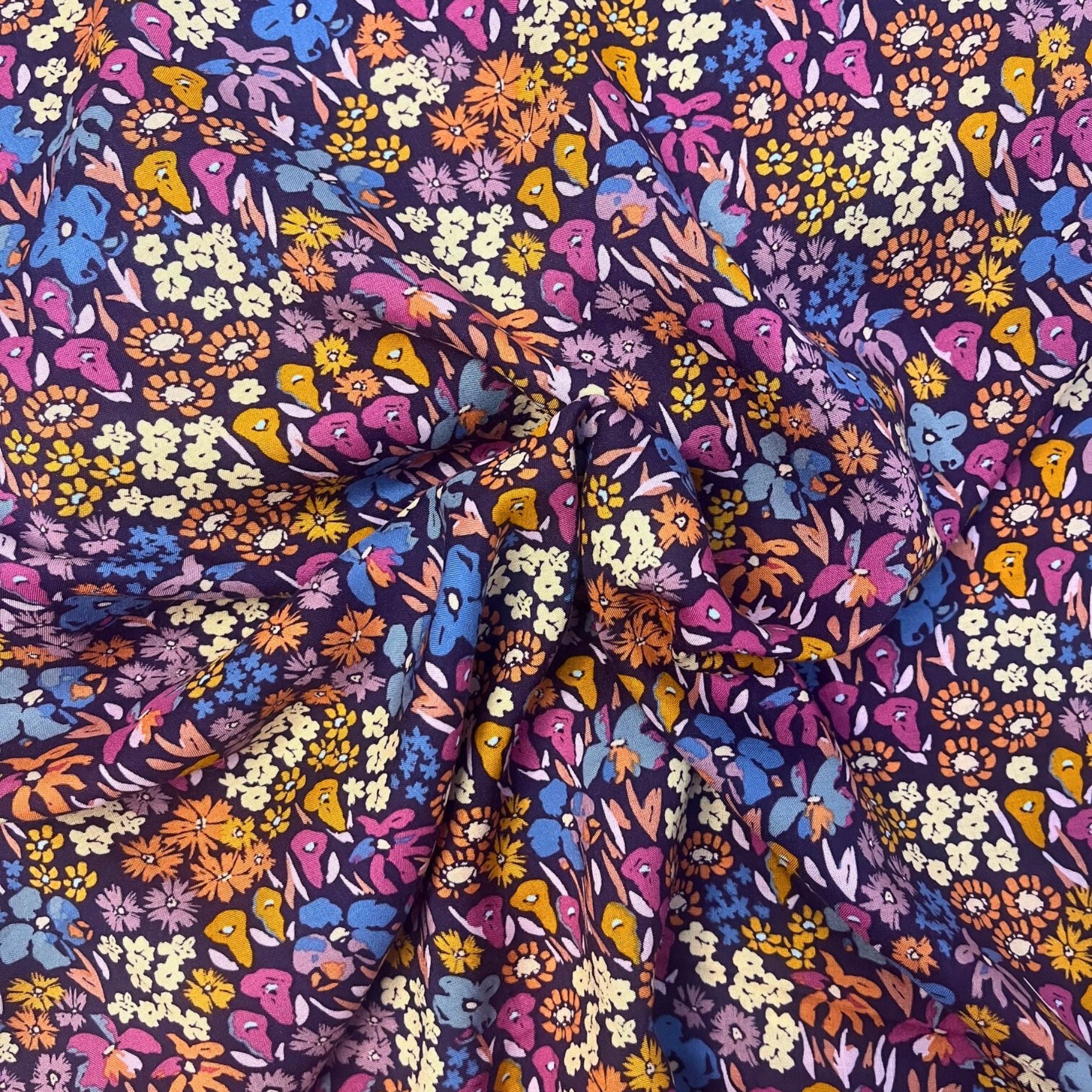 Flat lay of Bloomkind Meadow Dusk viscose rayon fabric draped to show fluid weight and twilight-toned botanical print