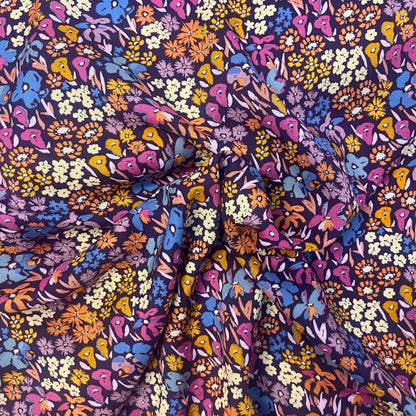 Flat lay of Bloomkind Meadow Dusk viscose rayon fabric draped to show fluid weight and twilight-toned botanical print