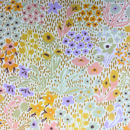 Pastel wildflower cotton jersey fabric draped to show its soft stretch and flow – beautiful for sewing t-shirts, leggings, or dresses