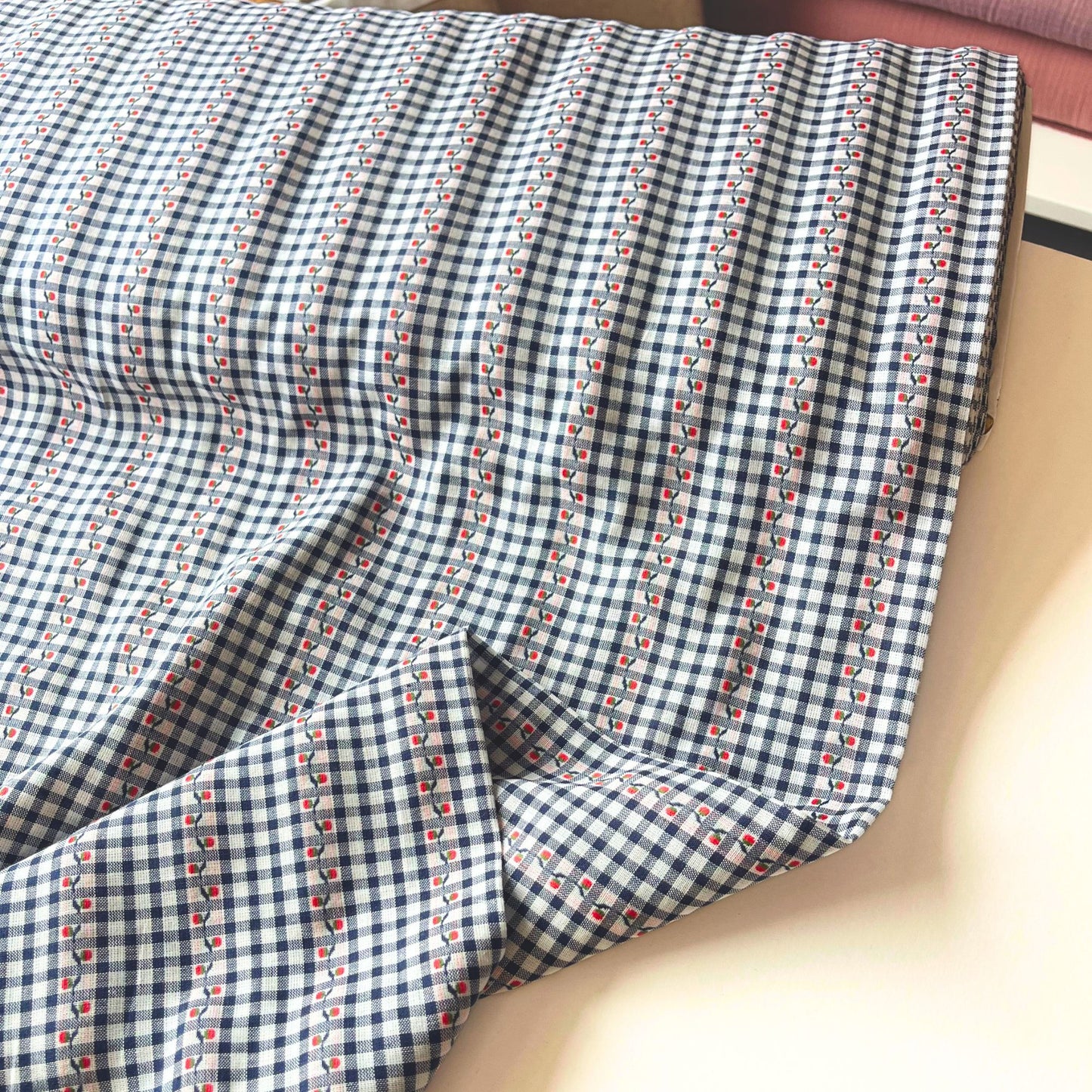 Close-up of navy and white mini gingham cotton fabric showing delicate raised jacquard floral pattern and red highlight detail — Oeko-Tex Standard 100 certified, ideal for slow fashion dressmaking