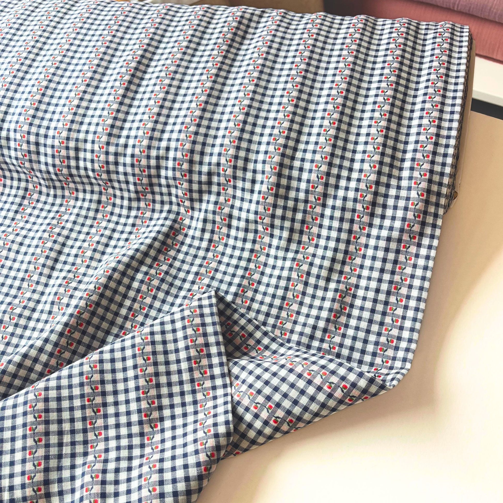 Close-up of navy and white mini gingham cotton fabric showing delicate raised jacquard floral pattern and red highlight detail — Oeko-Tex Standard 100 certified, ideal for slow fashion dressmaking