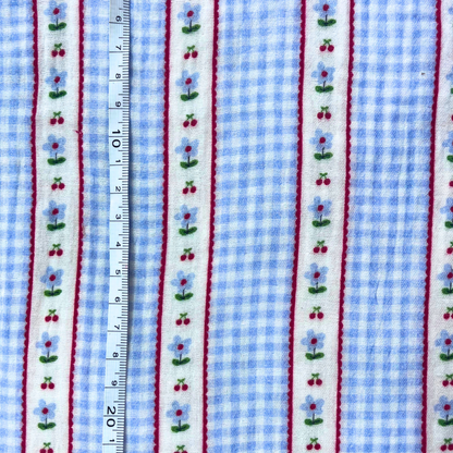 Flat lay of Poppy Fabrics double gauze digital check in light blue and white draped to show featherlight 125gsm weight and soft two-layer construction — gingham check with subtle vertical stripe detail perfect for handmade summer dresses and playsuits