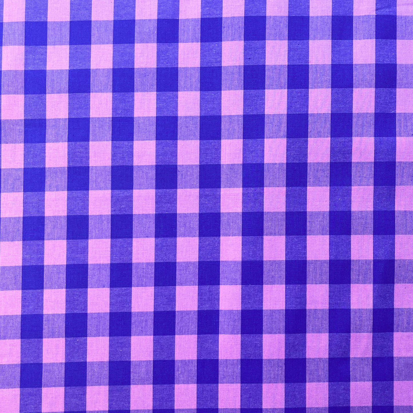 Close-up of blue and pink yarn dyed gingham check cotton fabric showing crisp 1.75cm check definition and soft woven texture — Oeko-Tex certified 115gsm woven ideal for slow fashion dressmaking and children's sewing