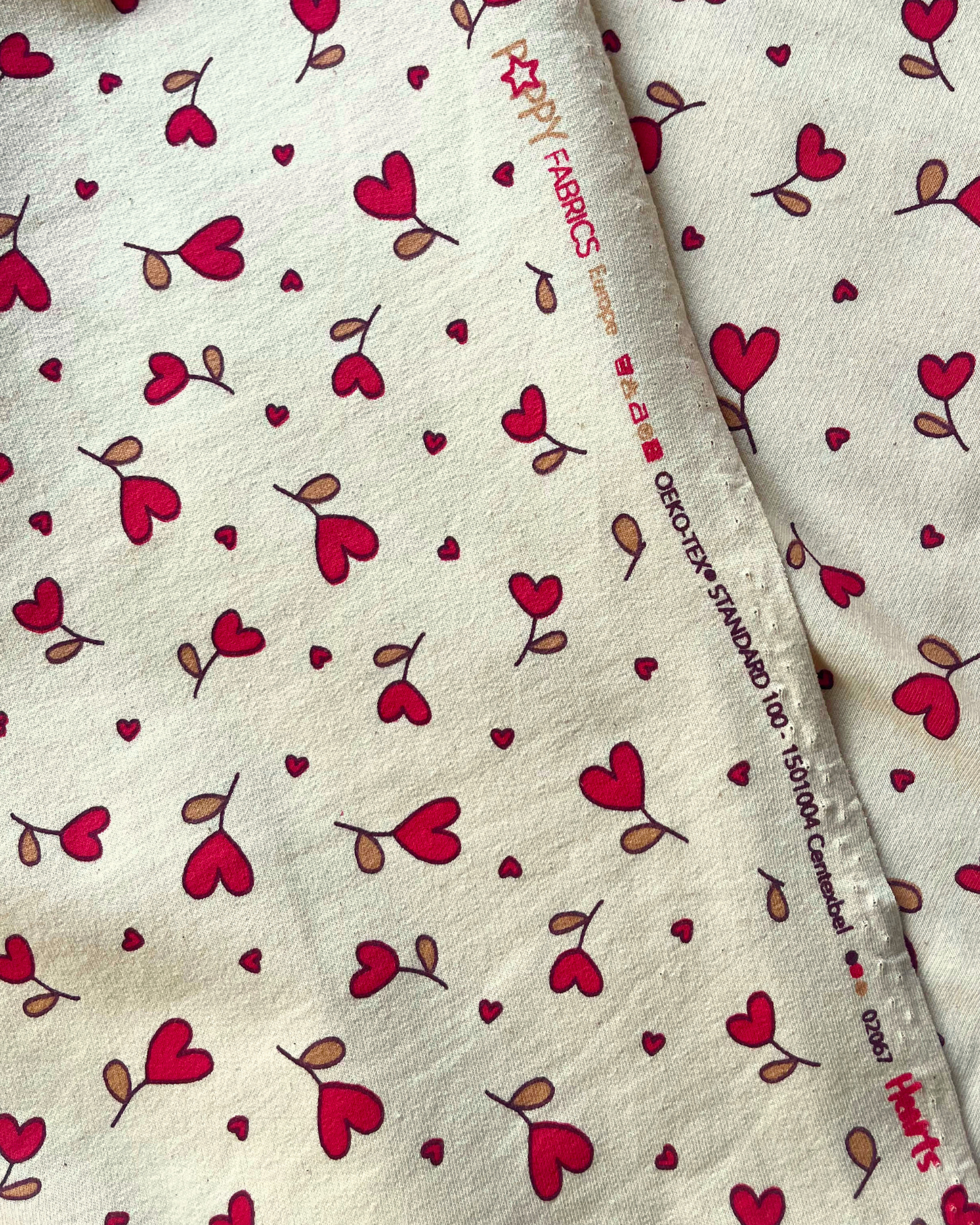 Supersoft brushed back sweatshirting in natural with small red hearts — Oeko-Tex Class 1 certified fabric for handmade baby gifts and children's loungewear
