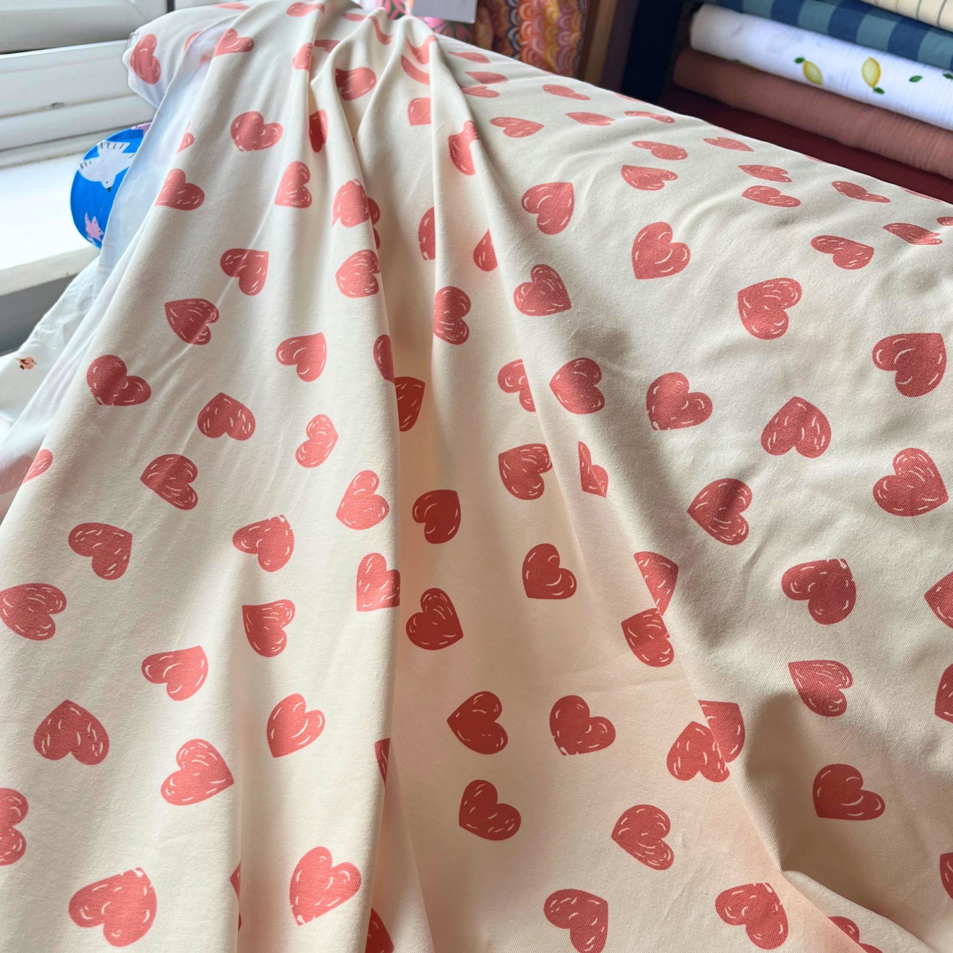 Cream cotton stretch jersey with scattered rose pink doodle heart print — 95% cotton 5% elastane knit, soft and gentle on sensitive skin, perfect for handmade children's rompers, dresses and everyday tops