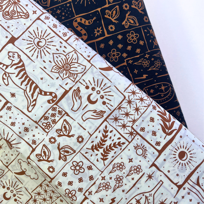 Black and white based celestial patchwork cotton poplin folded to show crisp woven construction and rich caramel and ginger tiger floral star print — lightweight breathable fabric ideal for handmade blouses, midi skirts and statement wide-leg trousers