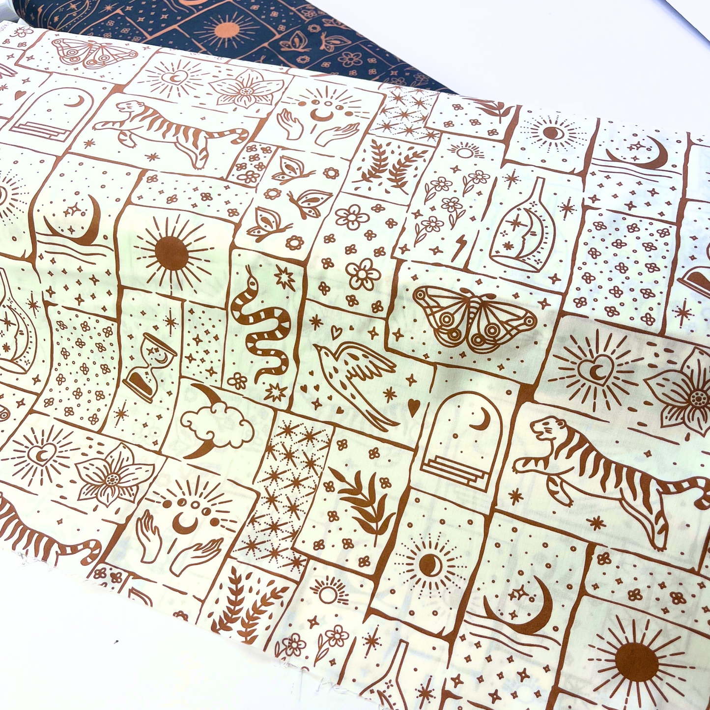 White cotton poplin with irregular caramel and ginger celestial patchwork print featuring tigers, florals, stars and moons — Oeko-Tex Standard 100 certified 100% cotton woven for bold slow fashion dressmaking and statement handmade garments