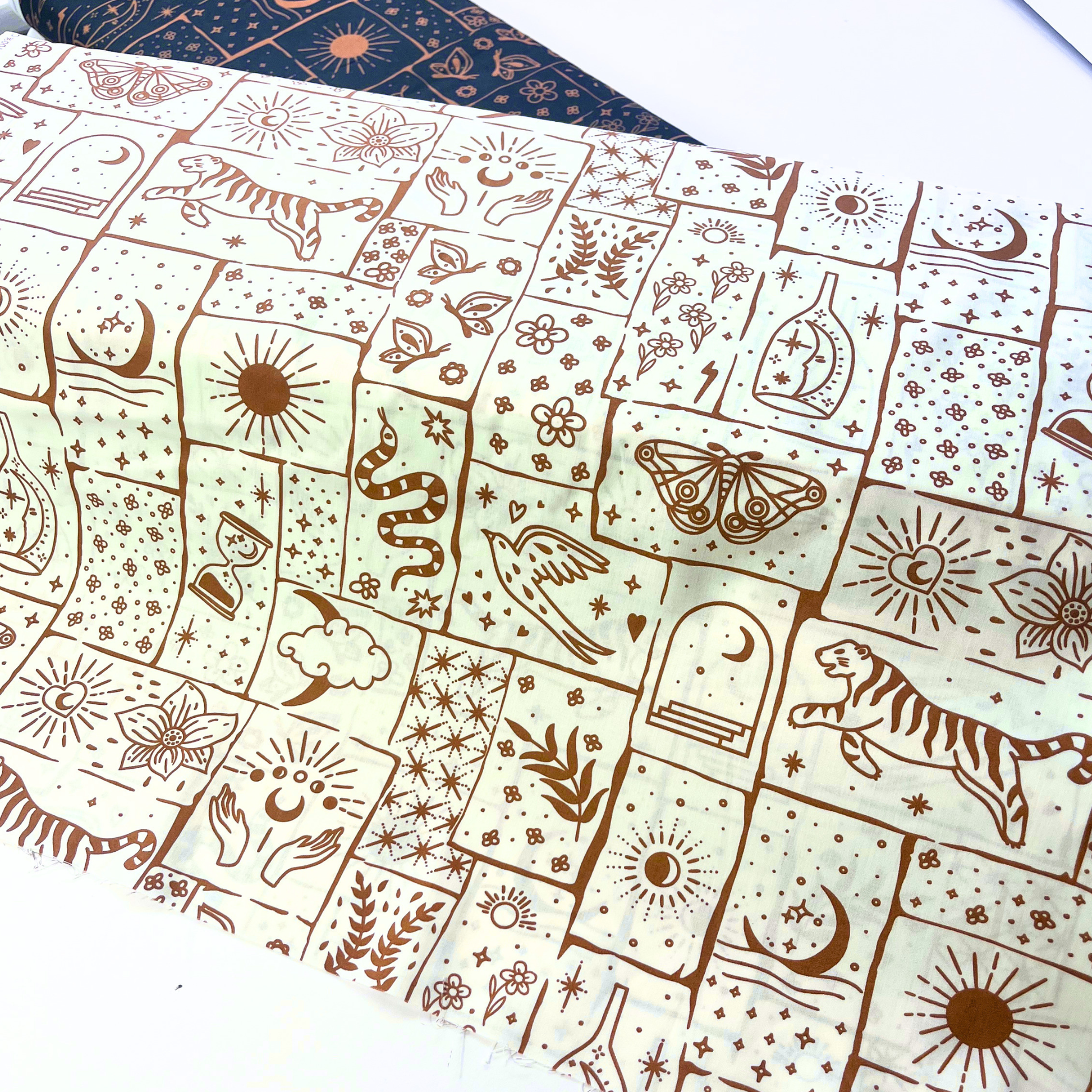 White cotton poplin with irregular caramel and ginger celestial patchwork print featuring tigers, florals, stars and moons — Oeko-Tex Standard 100 certified 100% cotton woven for bold slow fashion dressmaking and statement handmade garments