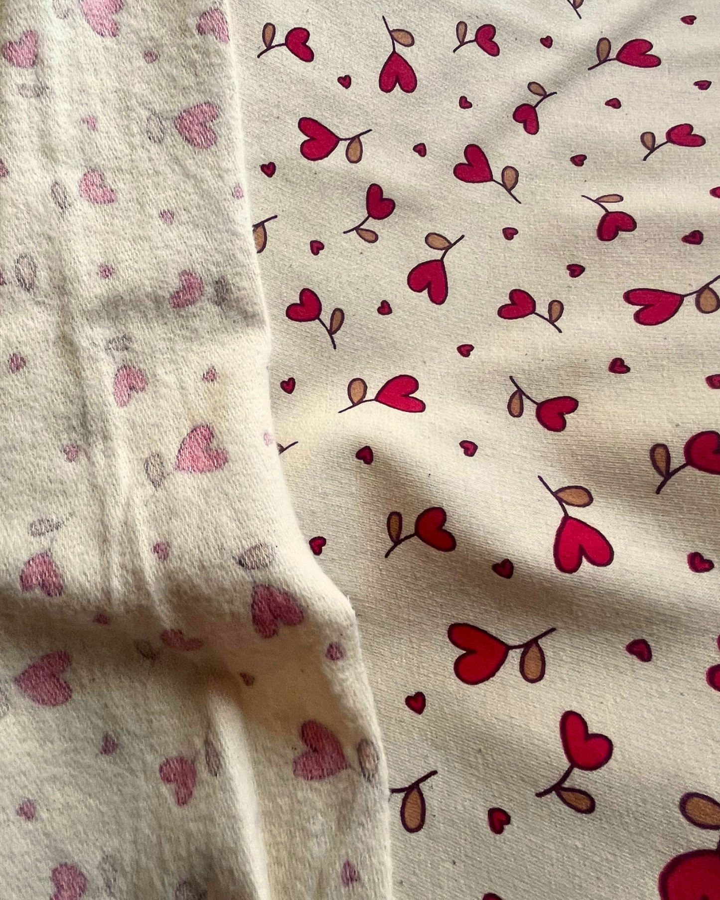 Natural and red heart print sweatshirting fabric folded to show soft brushed back — perfect for cosy handmade children's makes