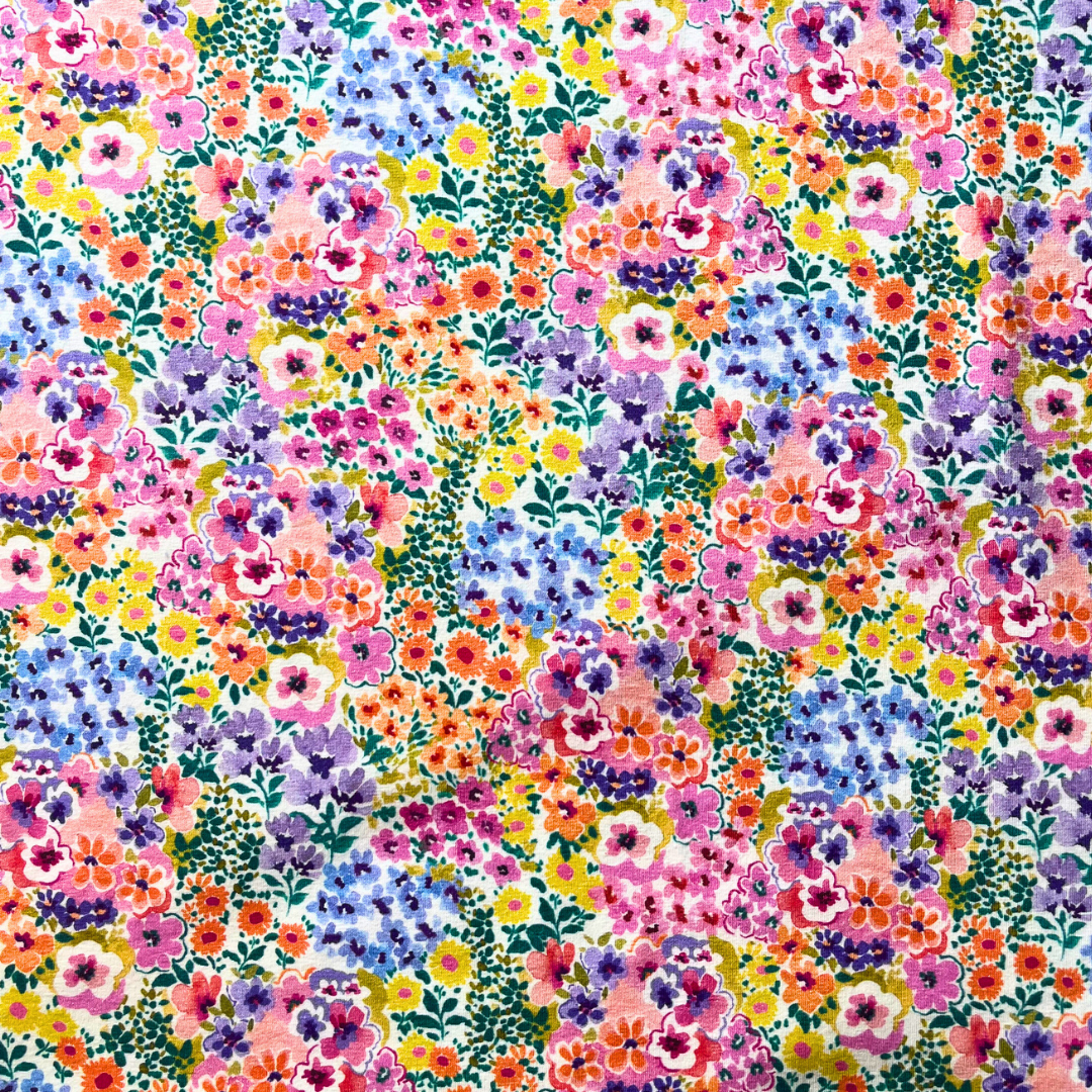 Densely packed multicolour floral print on cream stretch jersey fabric — Oeko-Tex Standard 100 certified 95% cotton elastane knit for slow fashion dressmaking and children's sewing