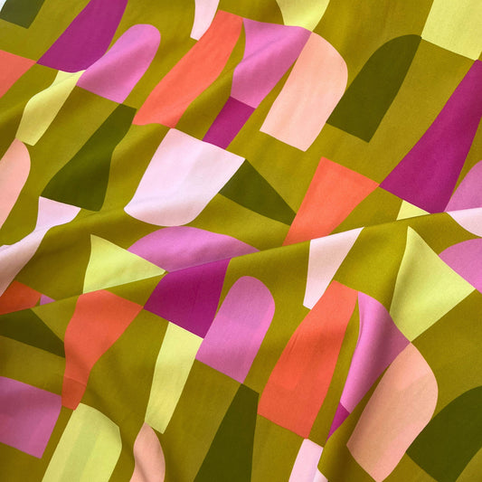 Close-up of LENZING™ ECOVERO™ viscose fabric in Shape Shifter print by Nerida Hansen, showing moss green background with bold modern block shapes.