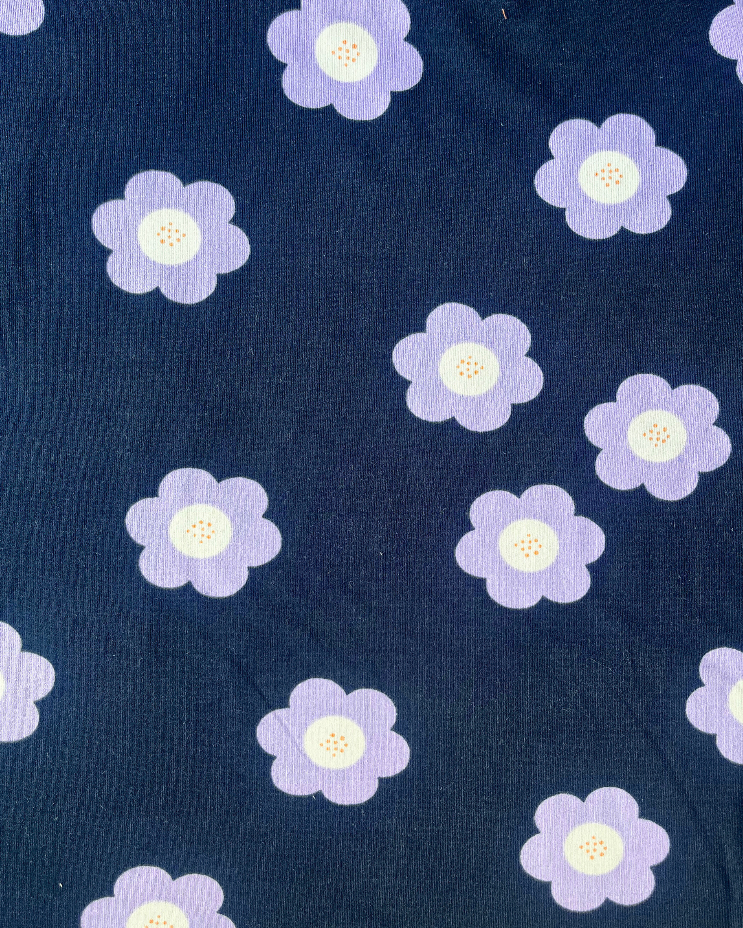Flat lay of Big Flowers French Terry in navy and lilac, bold retro floral print sweatshirting fabric draped to show weight and stretch — perfect for sweatshirts, joggers and sweatdresses