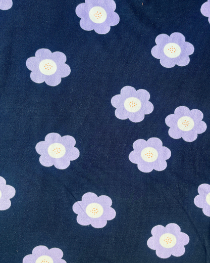 Flat lay of Big Flowers French Terry in navy and lilac, bold retro floral print sweatshirting fabric draped to show weight and stretch — perfect for sweatshirts, joggers and sweatdresses