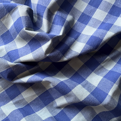 Close-up of blue and teal yarn dyed gingham showing crisp woven check lines and cool contemporary colour combination — Oeko-Tex Standard 100 certified cotton fabric for women's dressmaking