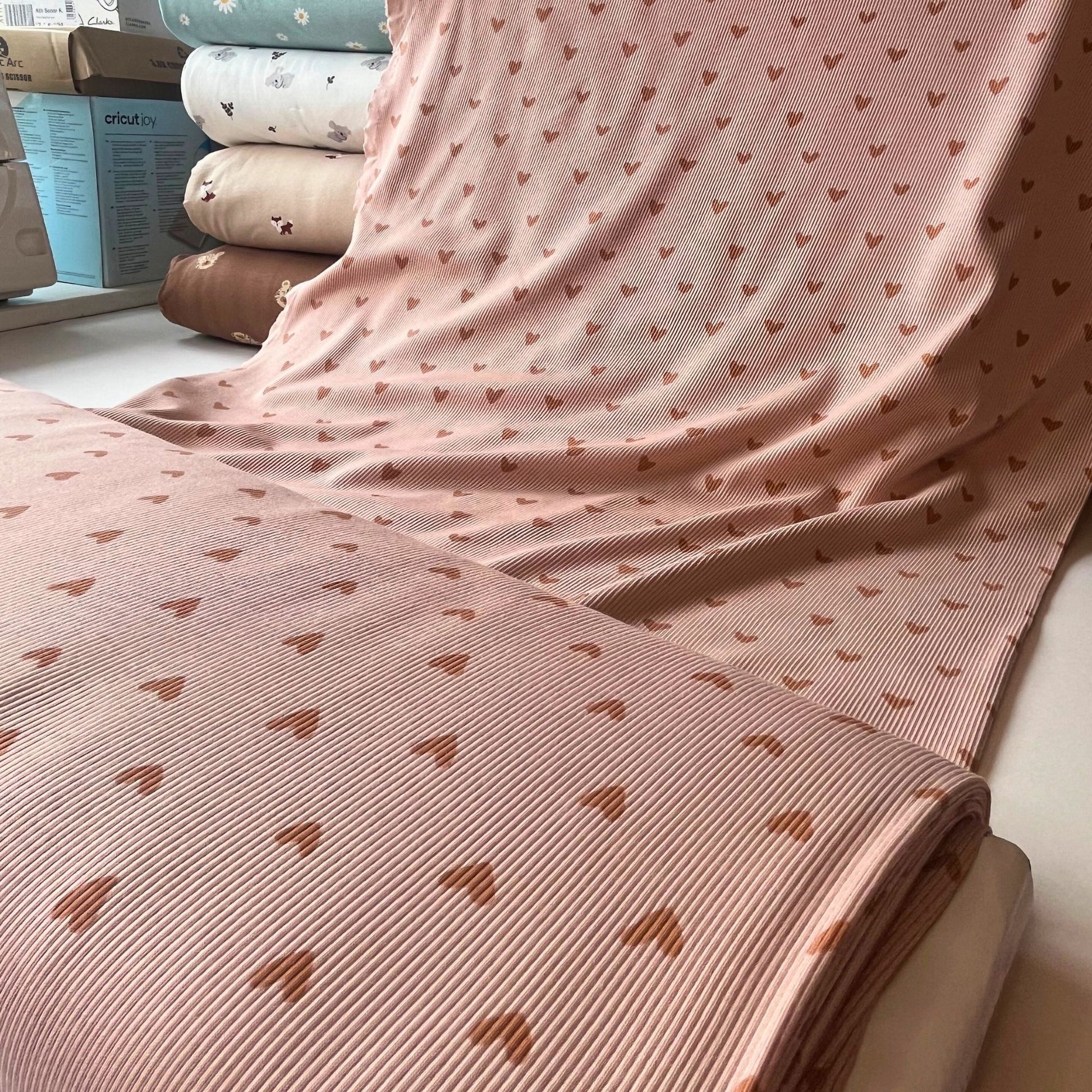 Neutral heart print fabric ideal for minimalist, Nordic-inspired kidswear.