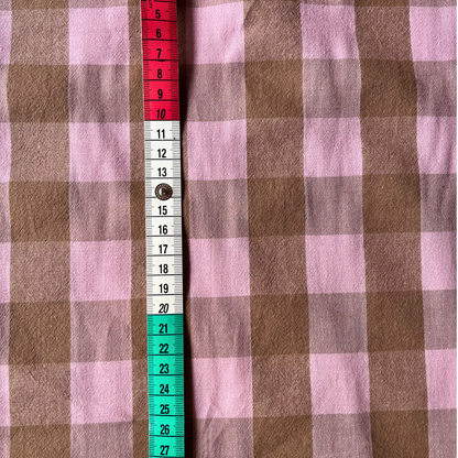 Flat lay of blush pink and brown gingham cotton fabric draped to show 135gsm weight and natural drape — 3cm check woven fabric perfect for handmade women's pinafores, blouses and wrap skirts in a beyond nine style