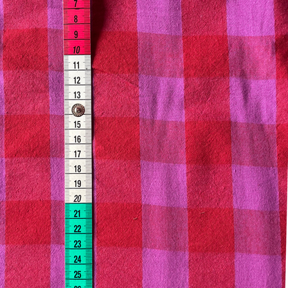 Flat lay of red and hot pink gingham cotton fabric draped to show 135gsm weight and natural drape — 3cm yarn dyed check perfect for handmade party dresses, shirts and barrel leg trousers