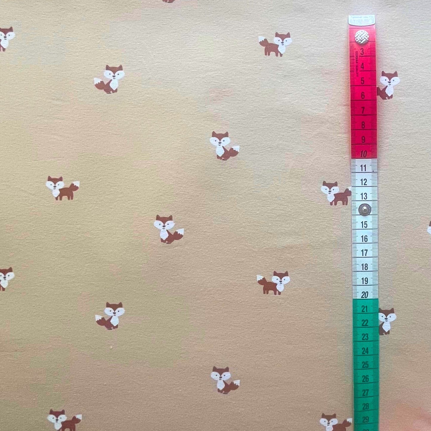 Soft neutral beige cotton jersey fabric with cute fox print for baby clothing.