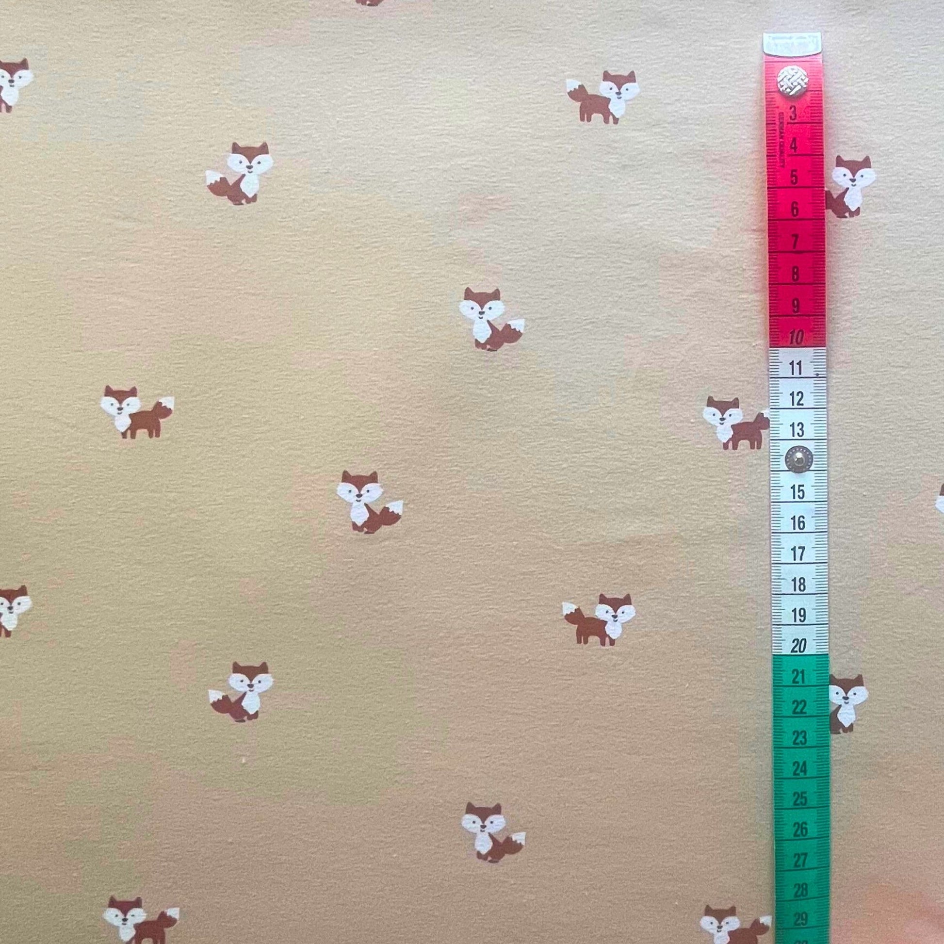 Soft neutral beige cotton jersey fabric with cute fox print for baby clothing.