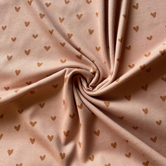 Close-up of fine ribbed jersey with soft Scandinavian-style heart pattern.