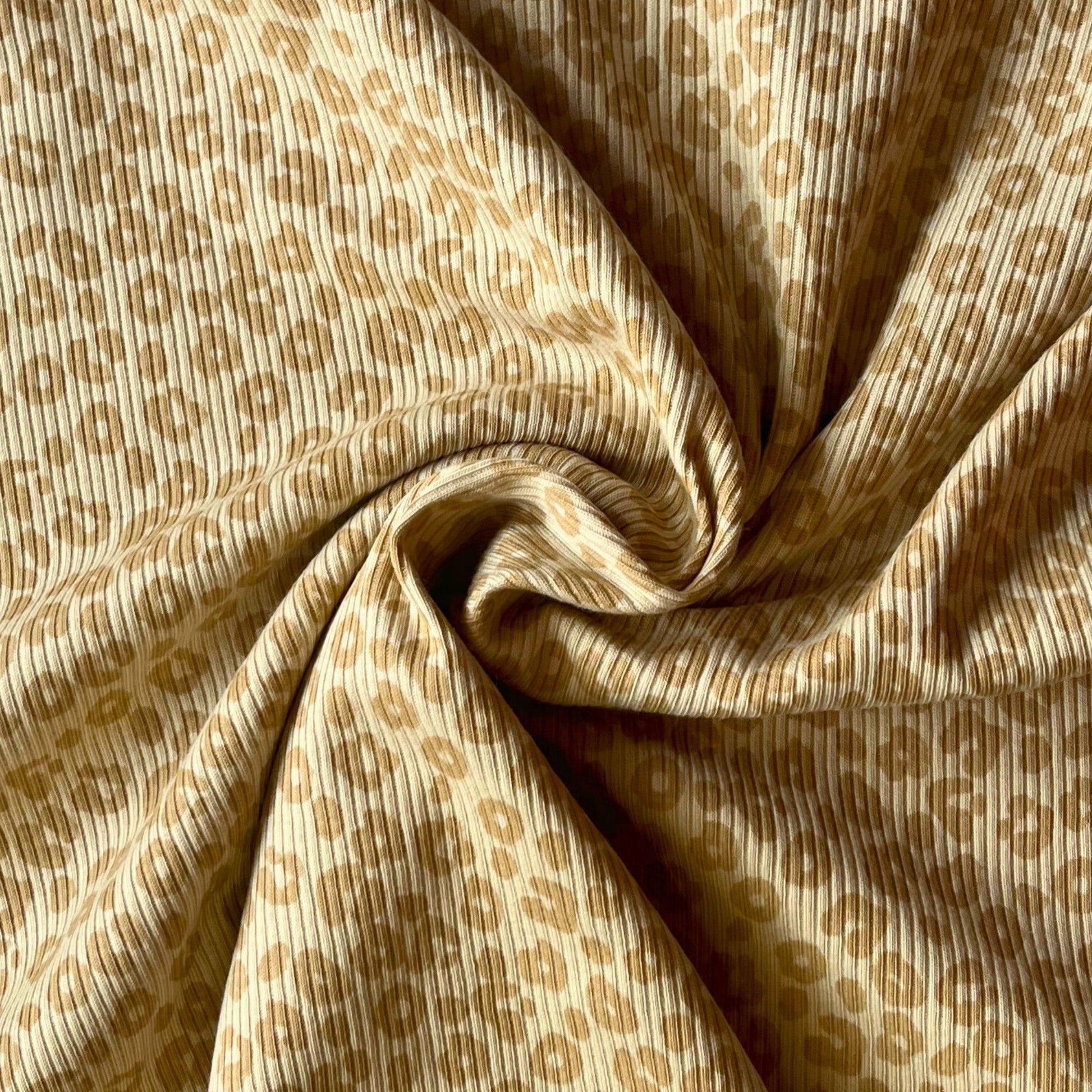 Close-up of fine rib knit texture with playful leopard print for children’s clothing.