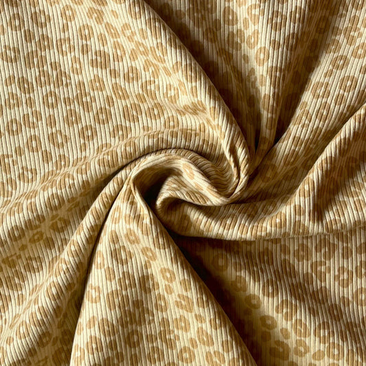 Close-up of fine rib knit texture with playful leopard print for children’s clothing.