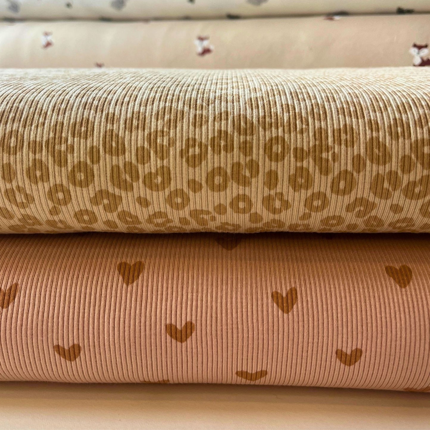 Two rolls of fabric with patterns on a beige background