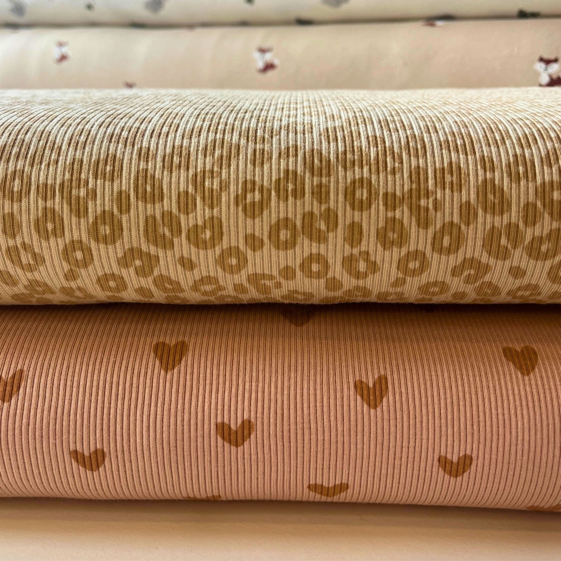 Two rolls of fabric with patterns on a beige background
