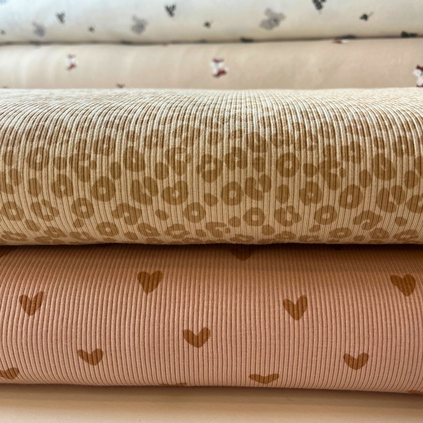 Folded view of leopard print rib knit jersey showing texture and elastic stretch.