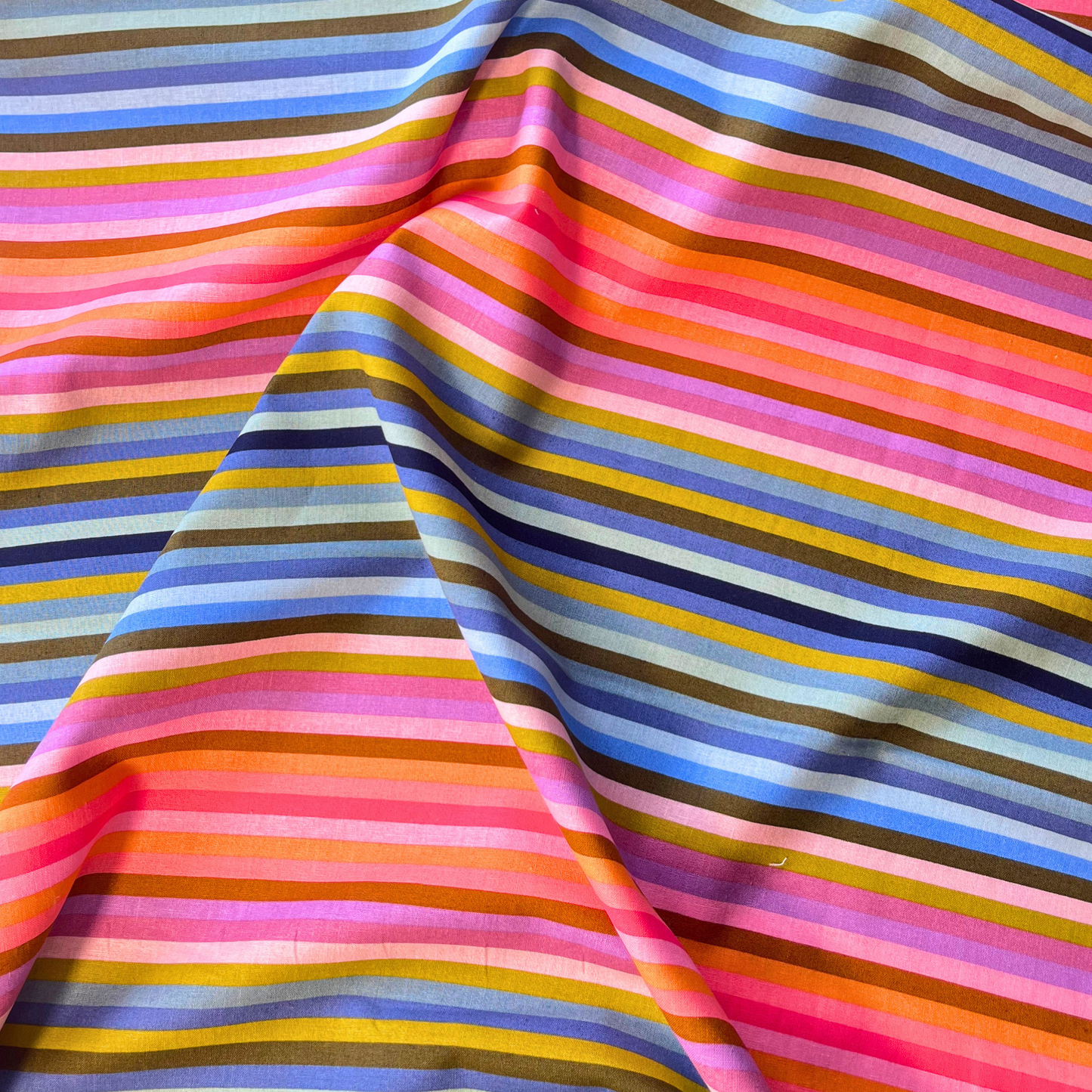 Close-up of Art Gallery Fabrics Starling rainbow stripe linen cotton blend fabric showing crisp 1cm multicolour stripe detail and natural linen texture — Oeko-Tex certified 165gsm slow fashion dressmaking fabric UK