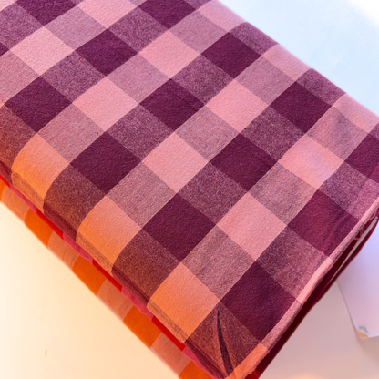 Aubergine and pale pink gingham check yarn dyed woven cotton fabric folded to show rich 3cm check definition — 145cm wide Oeko-Tex certified dressmaking fabric for handmade blouses pinafores dresses and autumn layering pieces