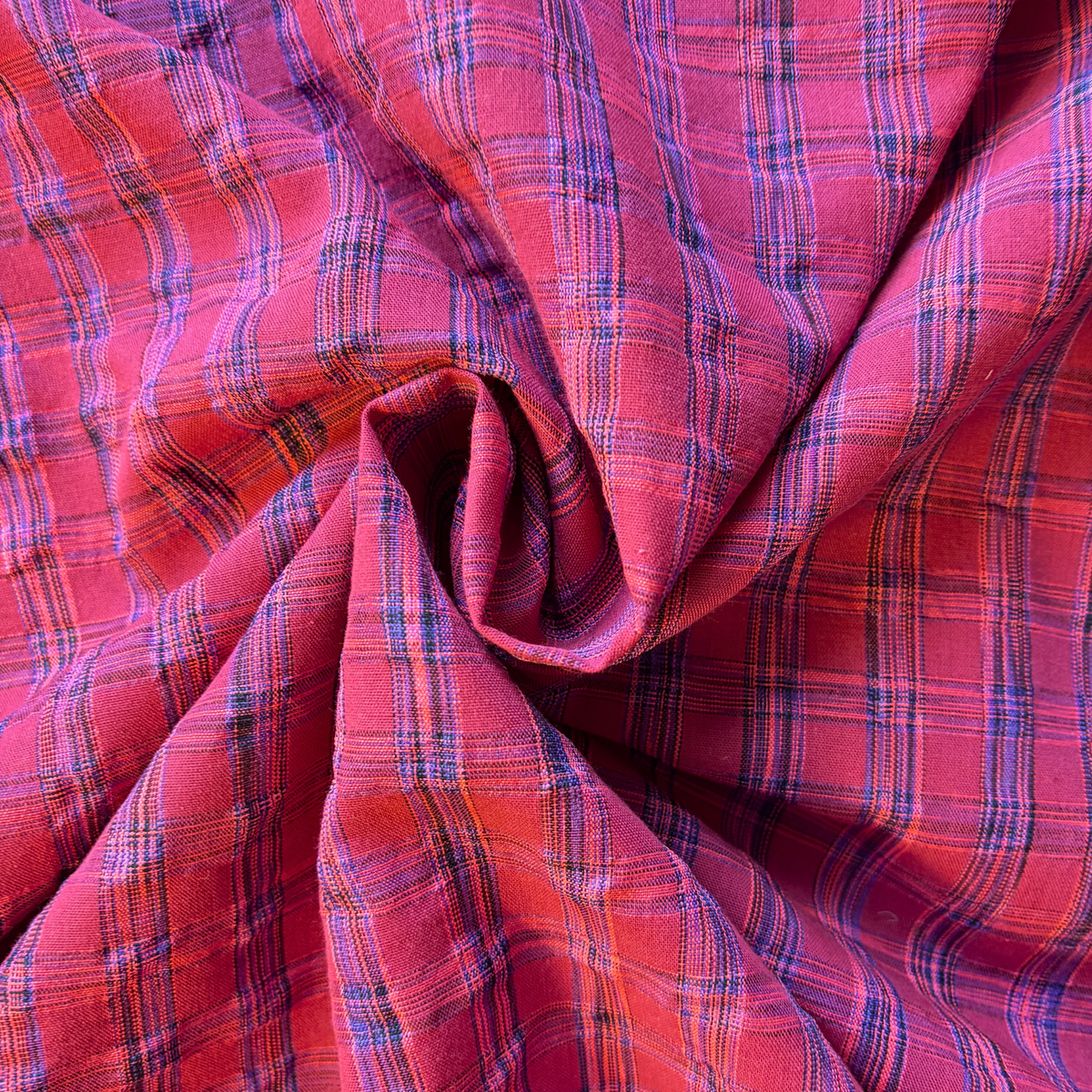 Berry neon pink and cobalt blue yarn dyed check woven fabric folded to show rippling iridescent check quality — 2cm check 142cm wide Oeko-Tex certified lightweight dressmaking fabric for handmade dresses and skirts