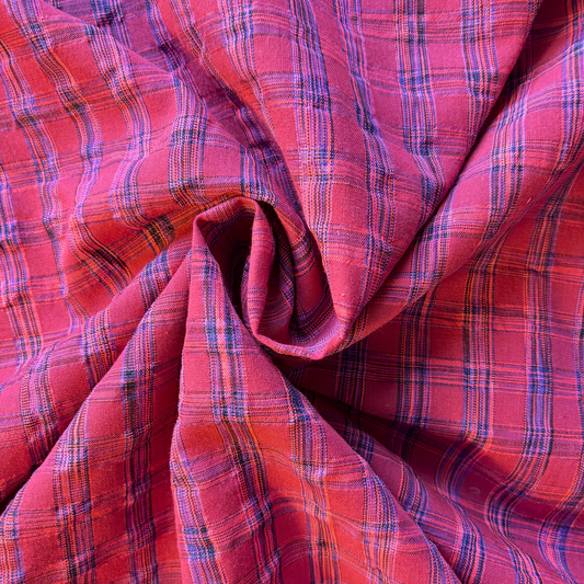 Berry neon pink and cobalt blue yarn dyed check woven fabric folded to show rippling iridescent check quality — 2cm check 142cm wide Oeko-Tex certified lightweight dressmaking fabric for handmade dresses and skirts