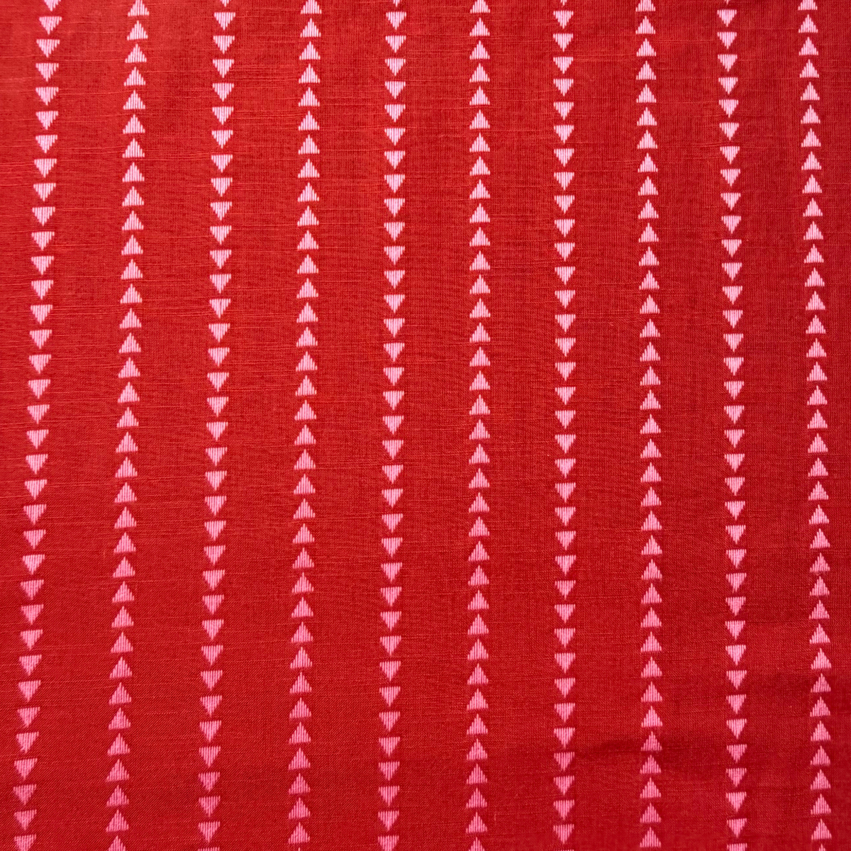 Burnt red pink dobby triangle stripe cotton fabric flat lay showing 135gsm natural drape and generous 145cm width — yarn dyed vertical mini triangle woven stripe perfect for handmade blouses dresses and wide-leg trousers