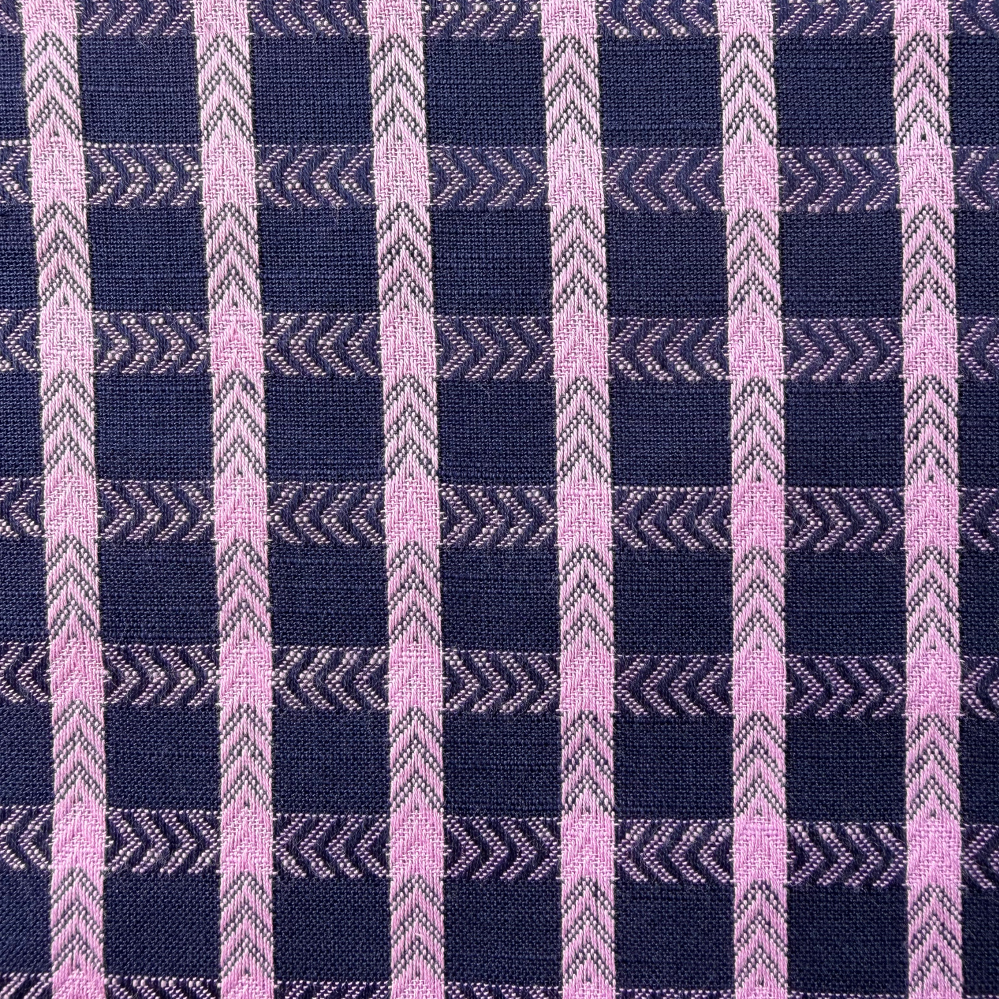 Close-up of navy and pop pink dobby check woven cotton fabric showing raised 1.8cm grid texture and soft woven construction — 135gsm slow fashion dressmaking fabric UK