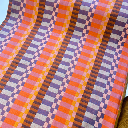 Flat lay of Fableism Plenty Broken Stripes orange cotton fabric draped to show 240gsm weight and 110cm width — multicolour broken stripe woven perfect for handmade autumn winter dresses jackets and wide-leg trousers