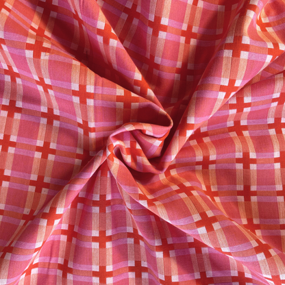 Close-up of Fableism Fine and Dandy Summer Decked Out woven cotton fabric showing warm pink base with cream and burnt orange 3.5cm grid check — heavyweight 240gsm slow fashion dressmaking fabric UK