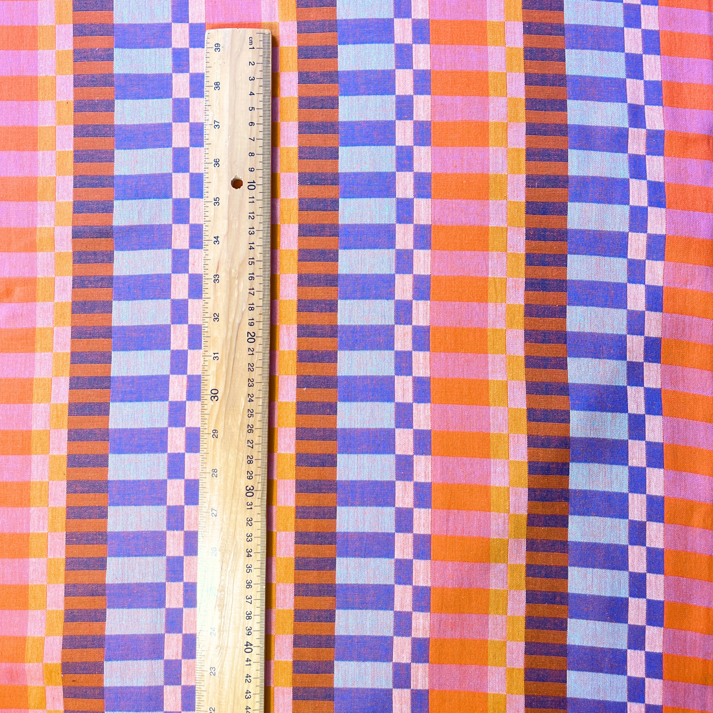 Fableism Plenty Broken Stripes orange multicolour woven cotton fabric folded to show scale and construction — 110cm wide autumn winter dressmaking fabric for dresses wide-leg trousers and chuck-on layers