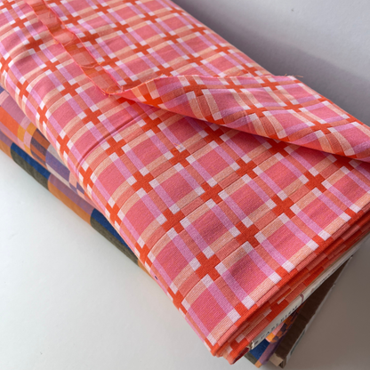 Close-up of Fableism Fine and Dandy Summer Decked Out woven cotton fabric showing warm pink base with cream and burnt orange 3.5cm grid check — heavyweight 240gsm slow fashion dressmaking fabric UK