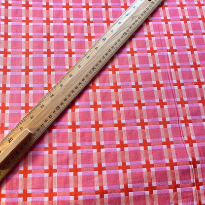 Flat lay of Fableism Summer Decked Out pink grid check cotton fabric draped to show substantial 240gsm weight and 110cm width — cream and burnt orange check perfect for handmade dresses jackets and transitional makes